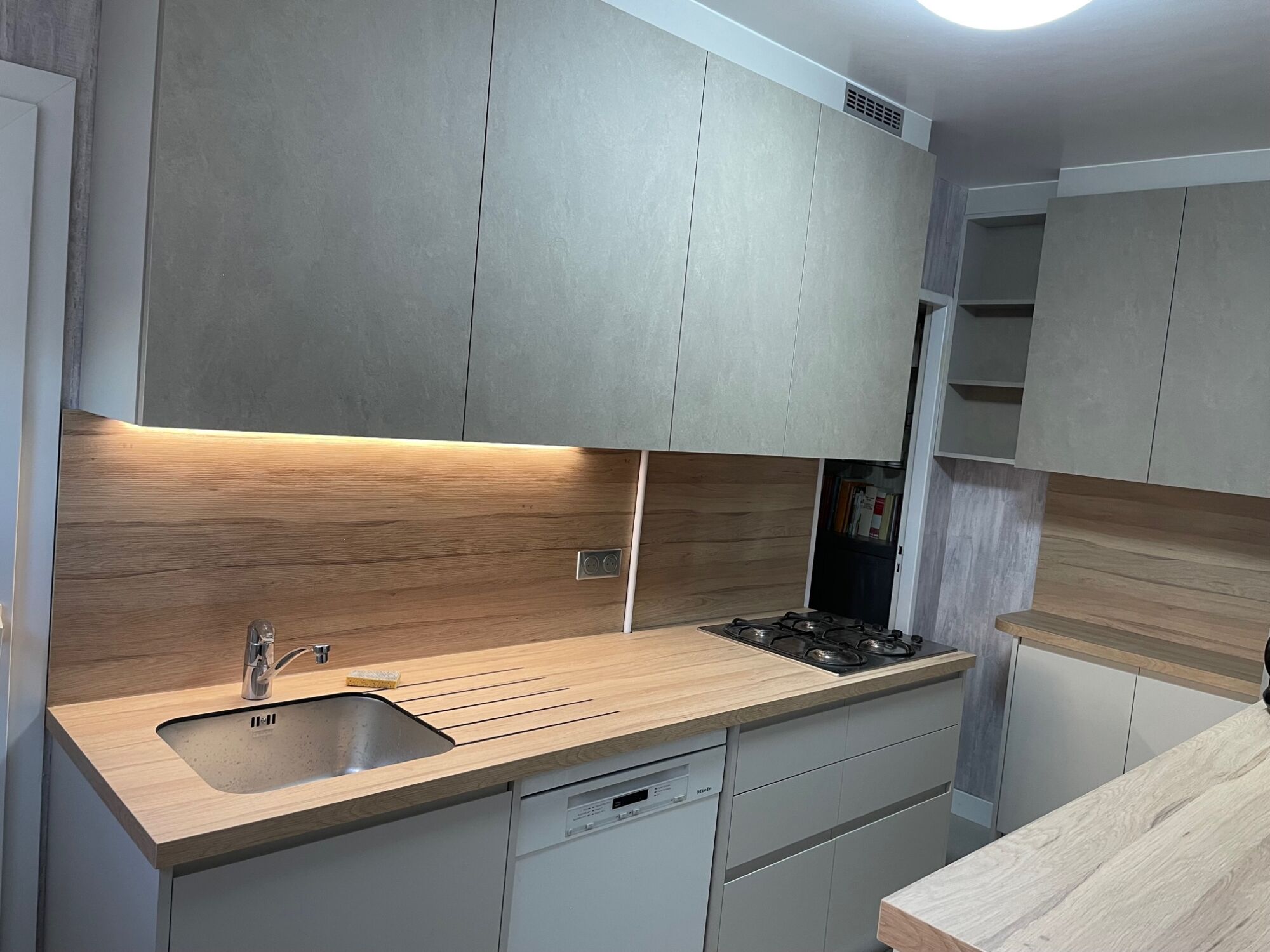 Pose cuisine finition pet cappuccino avec poign&eacute;e int&eacute;gr&eacute;e et nouvelle fa&ccedil;ade effet pierre en beige, plan de travail en Compact effet bois au coeur noir secteur STRASBOURG Brumath